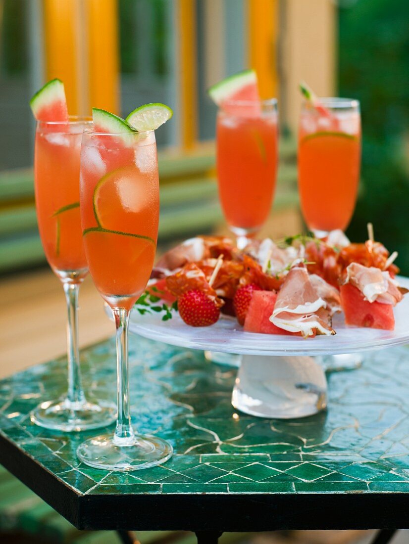 Melon drinks and fruit skewers with ham