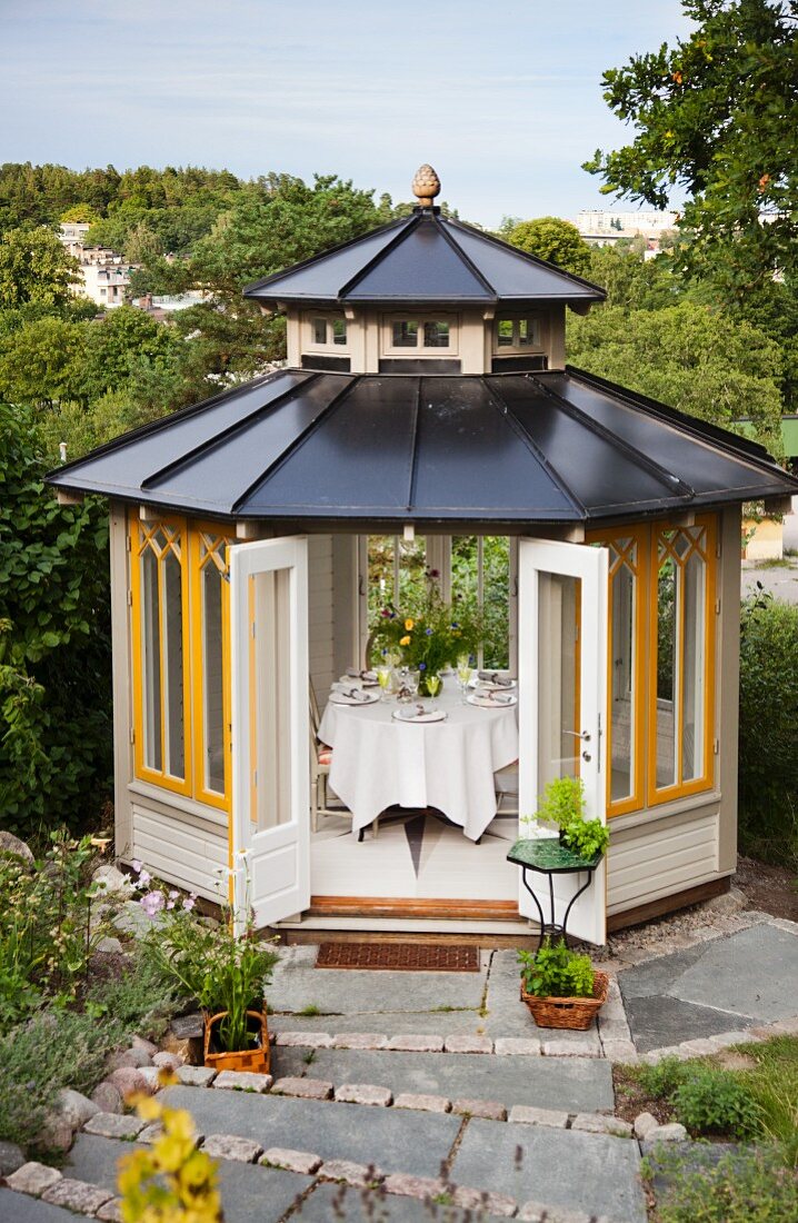 Blick auf einen Gartenpavillon mit gedecktem Tisch