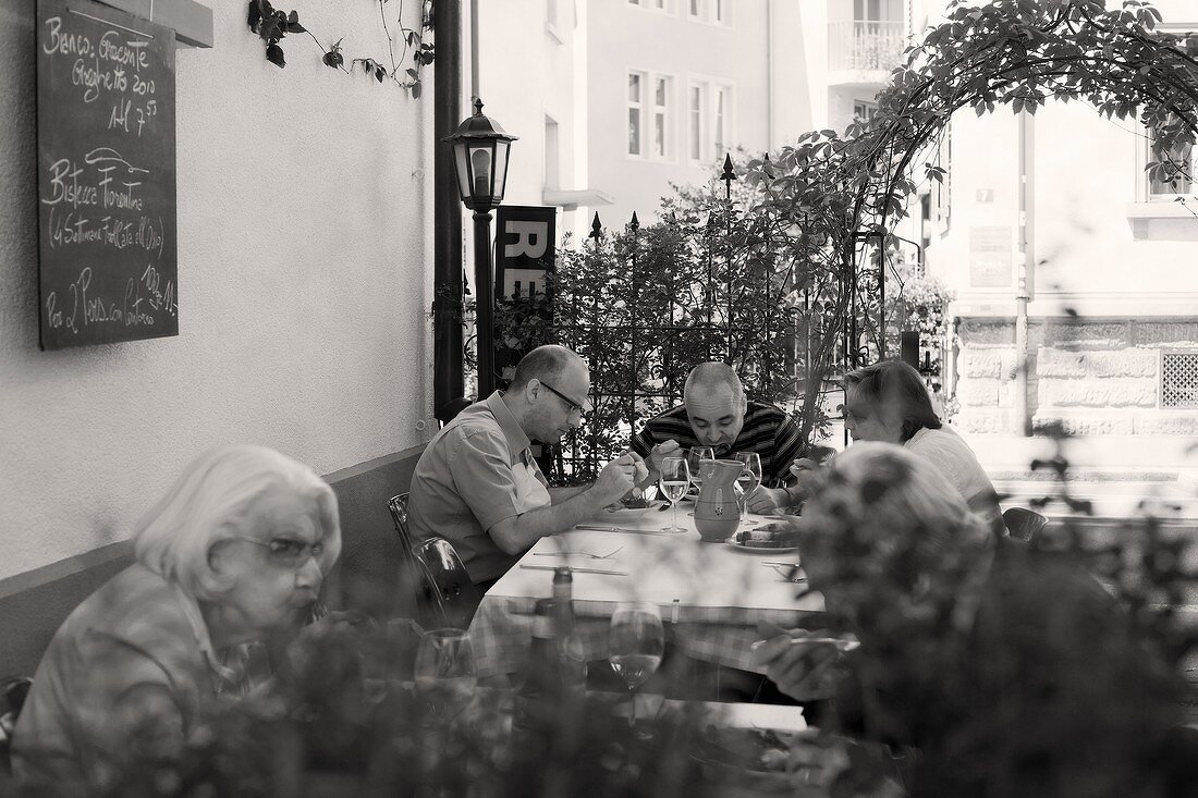 Gäste beim Essen auf der Terrasse eines italienischen Restaurants