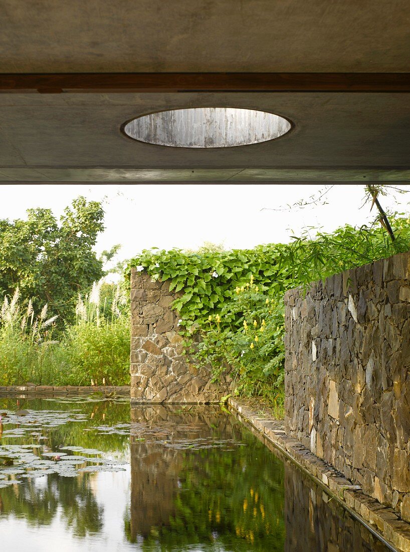 Pond and stone walls in front of house