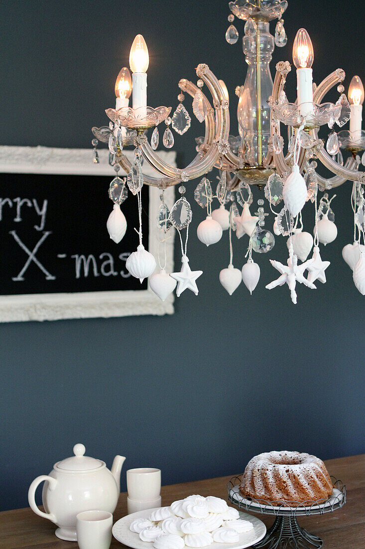 Bundt cake with icing sugar and chandelier with Christmas decorations