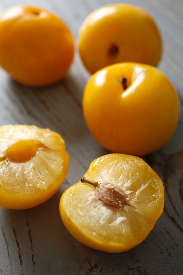 Yellow plums, halved and whole