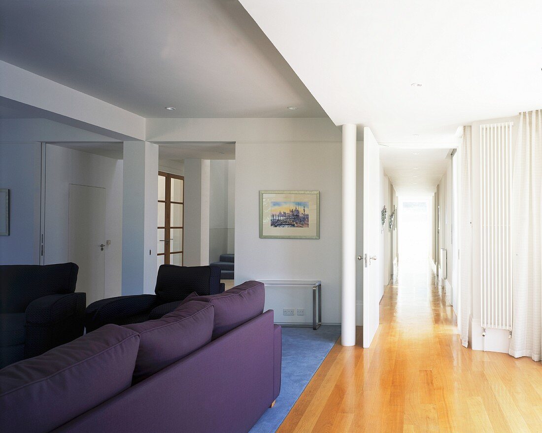 Living room with purple sofa set and open door to hallway