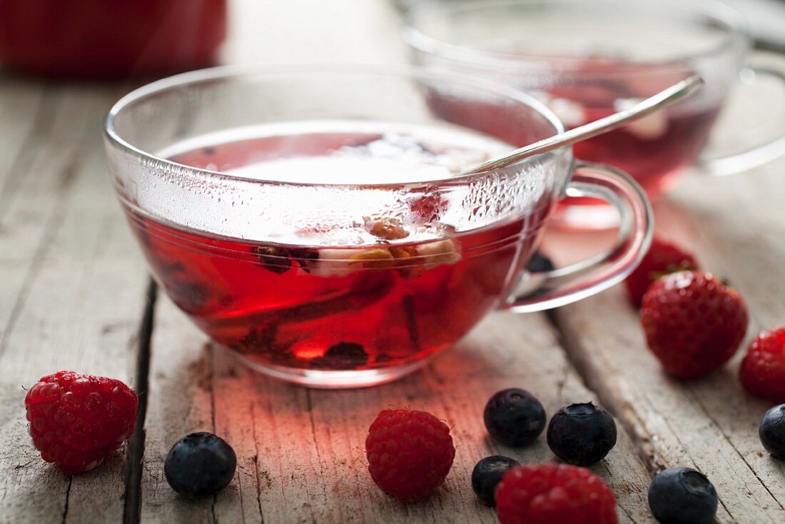 A cup of tea with berries