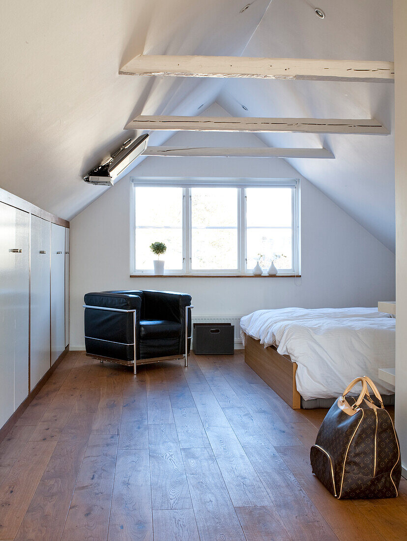 Bedroom with wooden floor and sloping ceiling