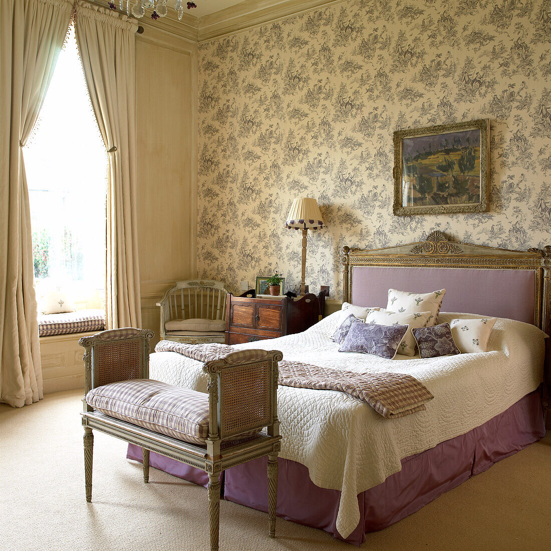 Bedroom with toile de jouy wallpaper and large bed in purple with ornaments