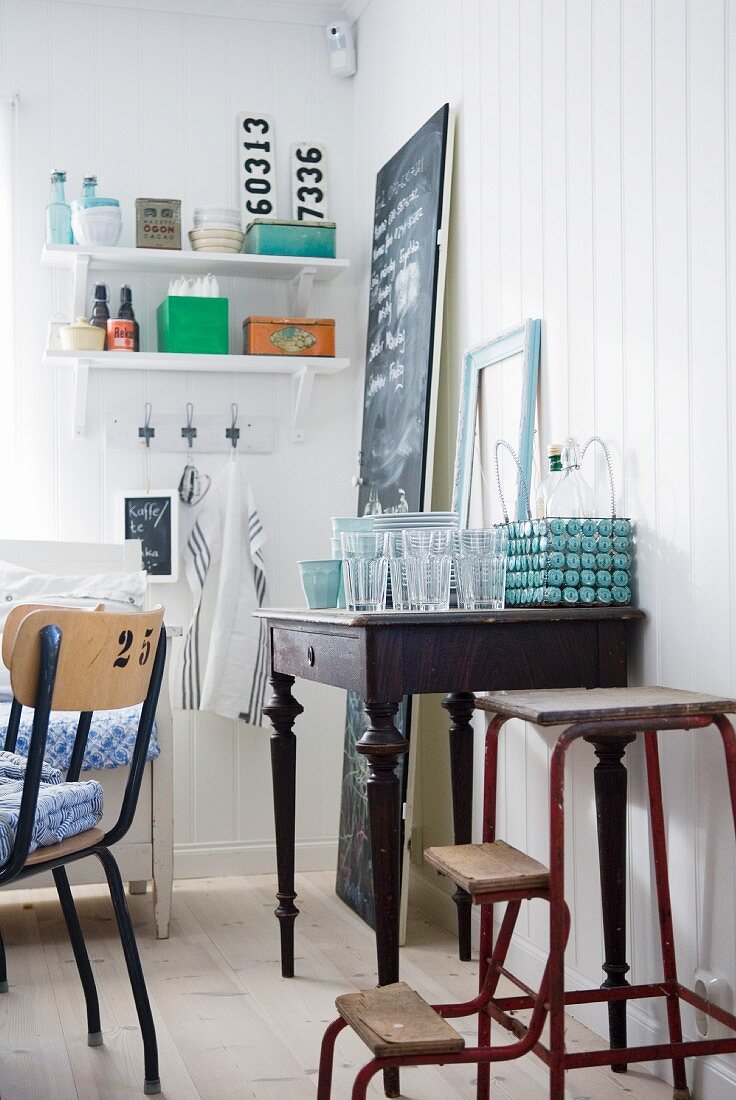Vintage step ladder next to old writing desk used as sideboard in dining room