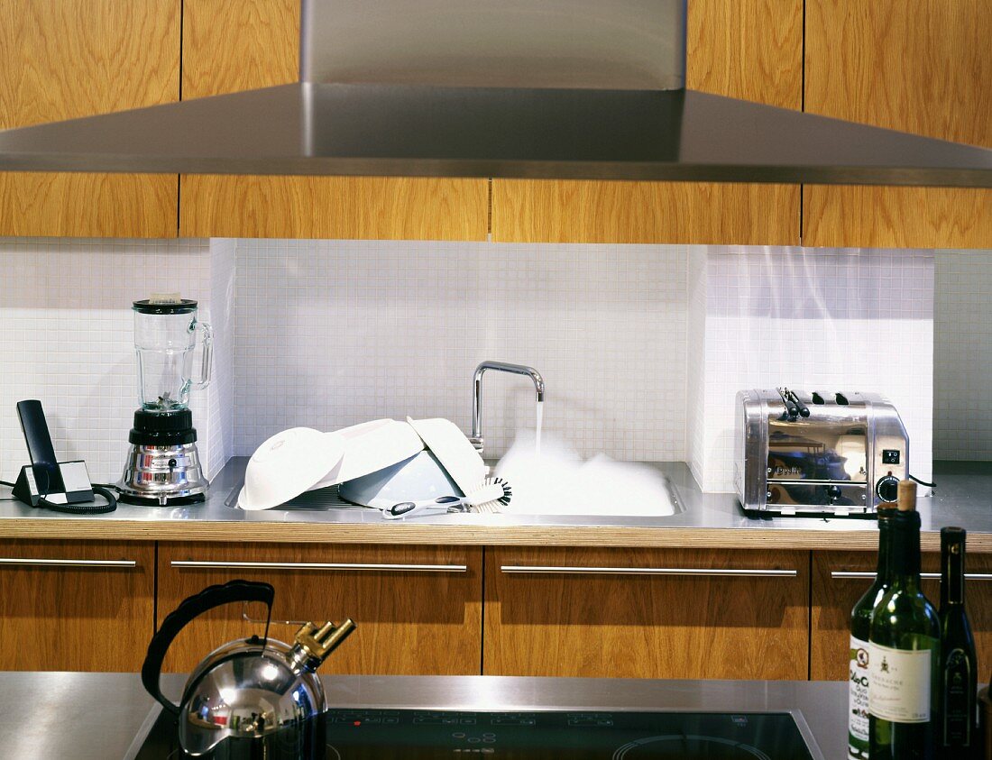 Extractor hood in front of modern, wooden fitted kitchen