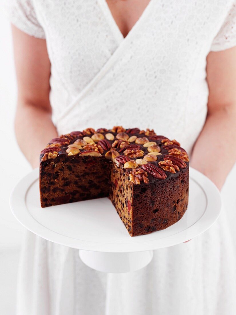 A woman holding a Christmas cake