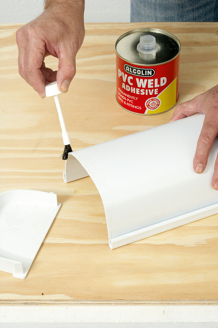 Painting the edge of a white plastic container with glue