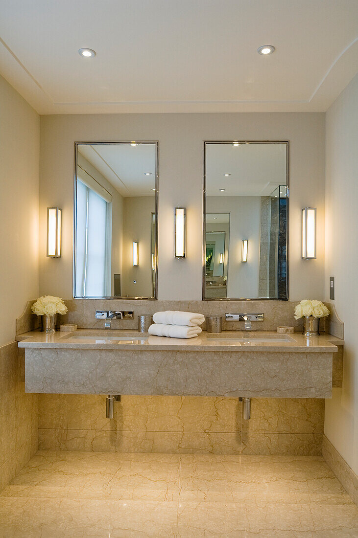 Double washbasin with marble top and wall mirror in bathroom