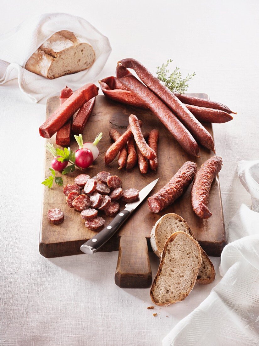 Various sausages (Landjäger, Bergwurz, Kaminwurzen), bread and radishes