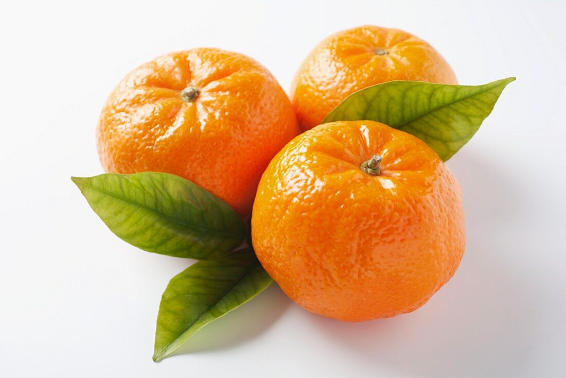 Drei Mandarinen mit Blättern