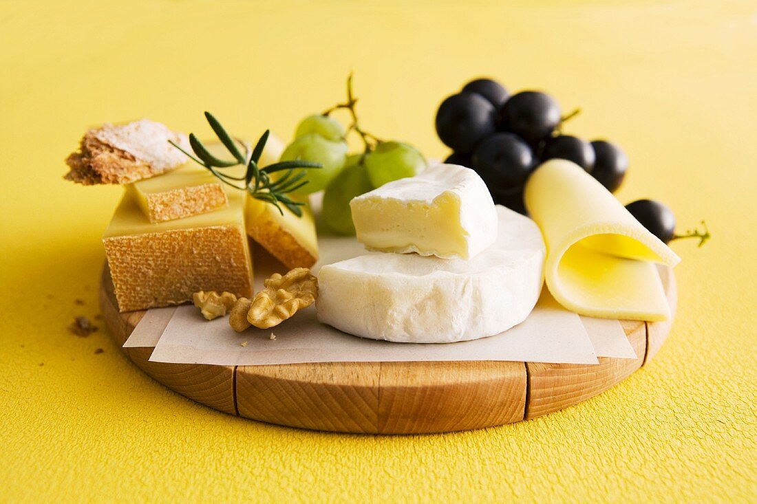 A cheese plater with grapes and nuts