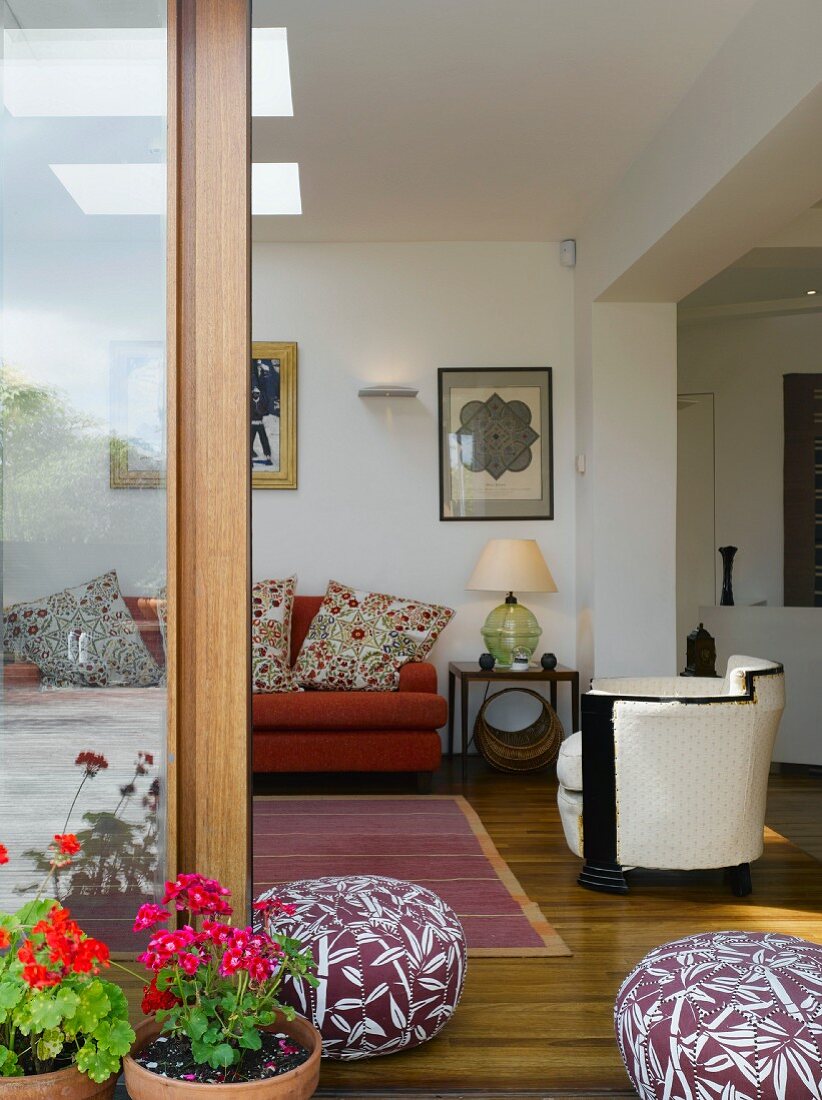 View of living room with sofa, armchair & floor cushions