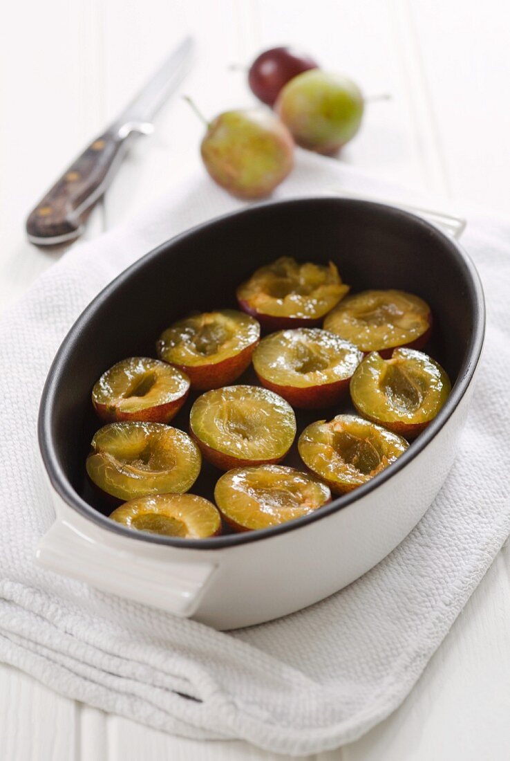 Halved plums in a baking dish