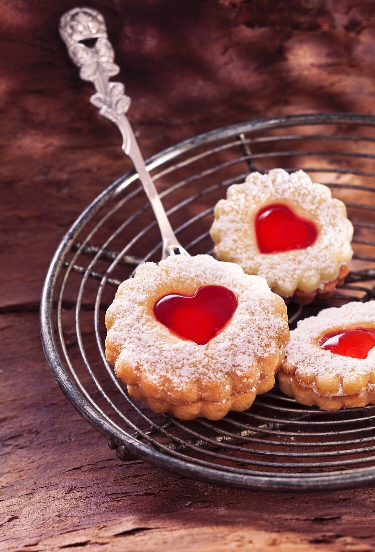 Shortbread biscuits with jam hearts on a wire rack