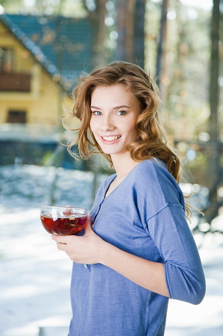 A young woman with a cup of fruit tea