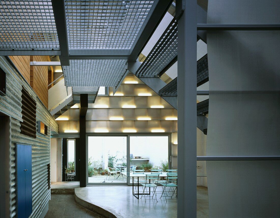 Staircase in loft-style living space and dining area on curved platform