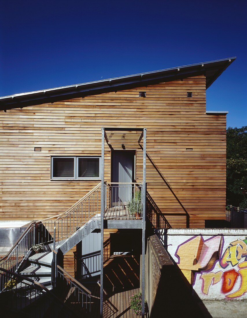 Modern house with wooden facade and access via metal steps