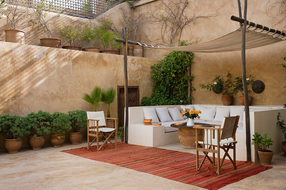 Terrasse mit Sitzbereich, modernen Holzstühlen und Topfpflanzen