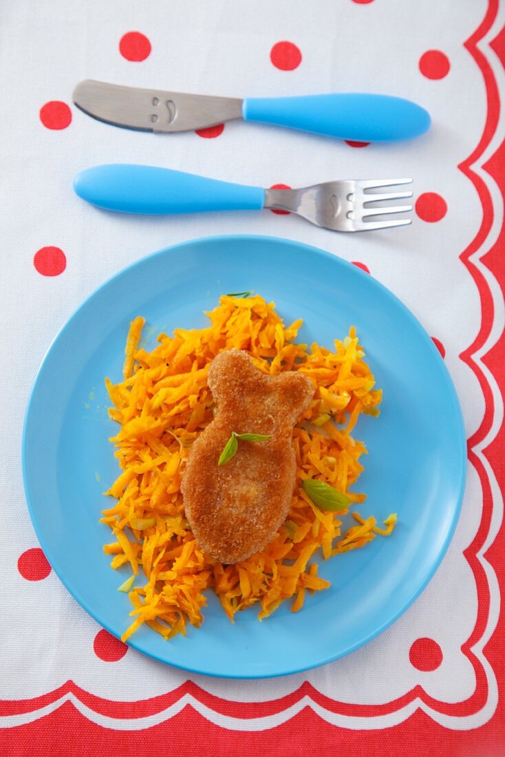 A fish-shaped fillet on a bed of grated carrots (seen from above)