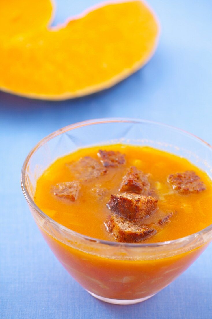 Pumpkin soup in a glass bowl with croutons