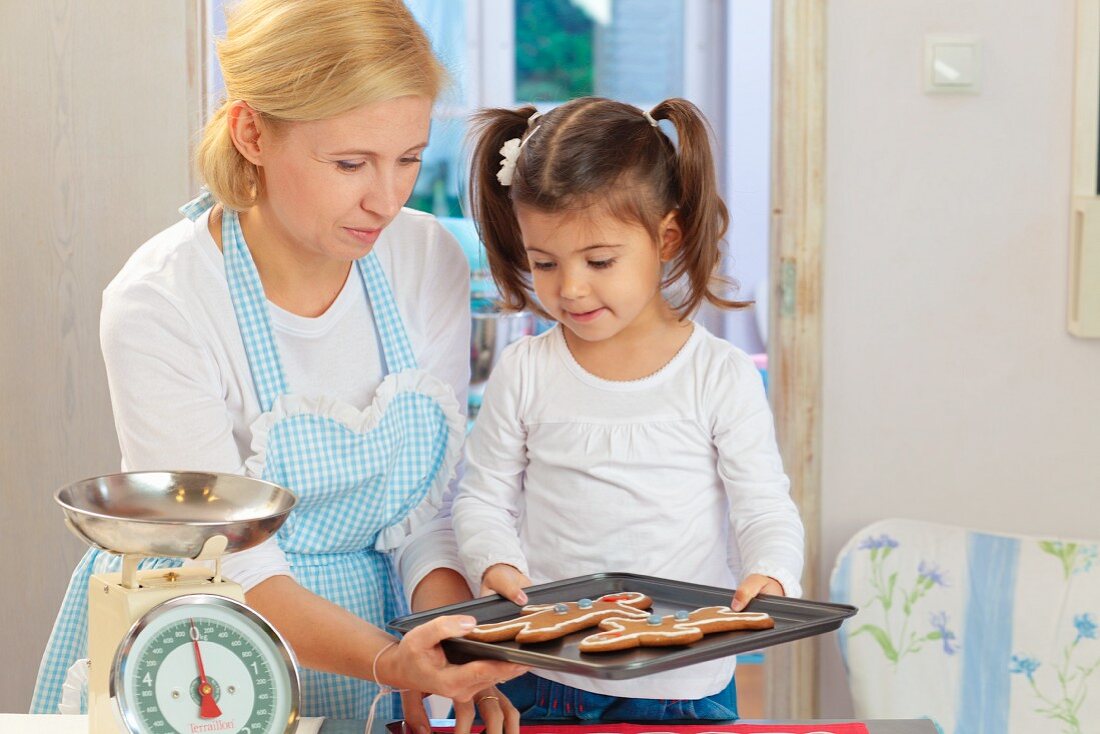 A mother and daughter baking gingerbread men