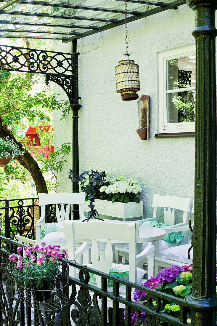 Terrace with white furniture and hanging lantern in summer