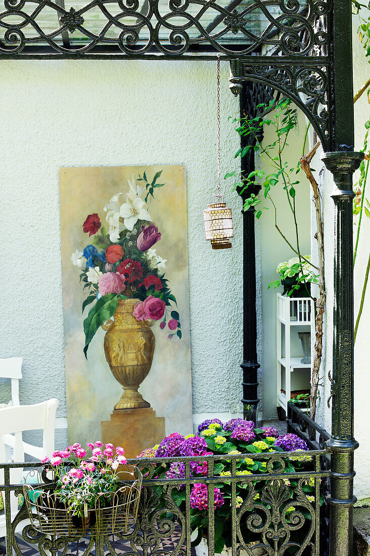 Romantische Terrassenecke mit Blumenbild und schmiedeeisernem Geländer