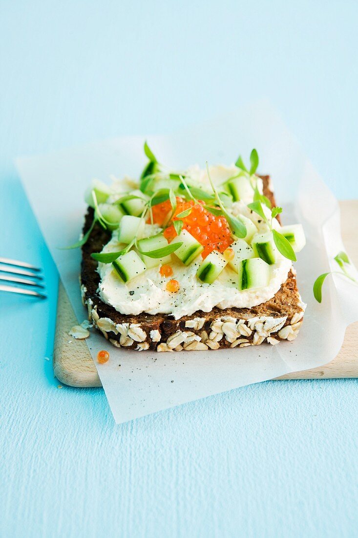 A slice of wholemeal bread topped with trout cream, cucumber and caviar