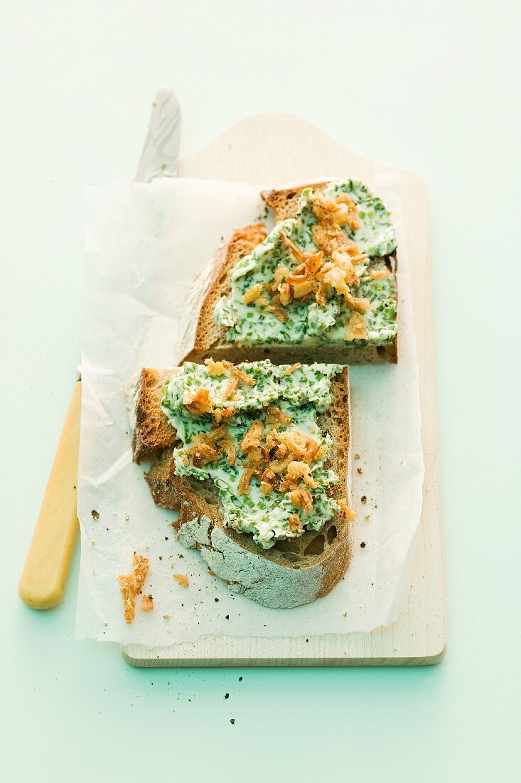 A slice of bread topped with chive butter and roast onions