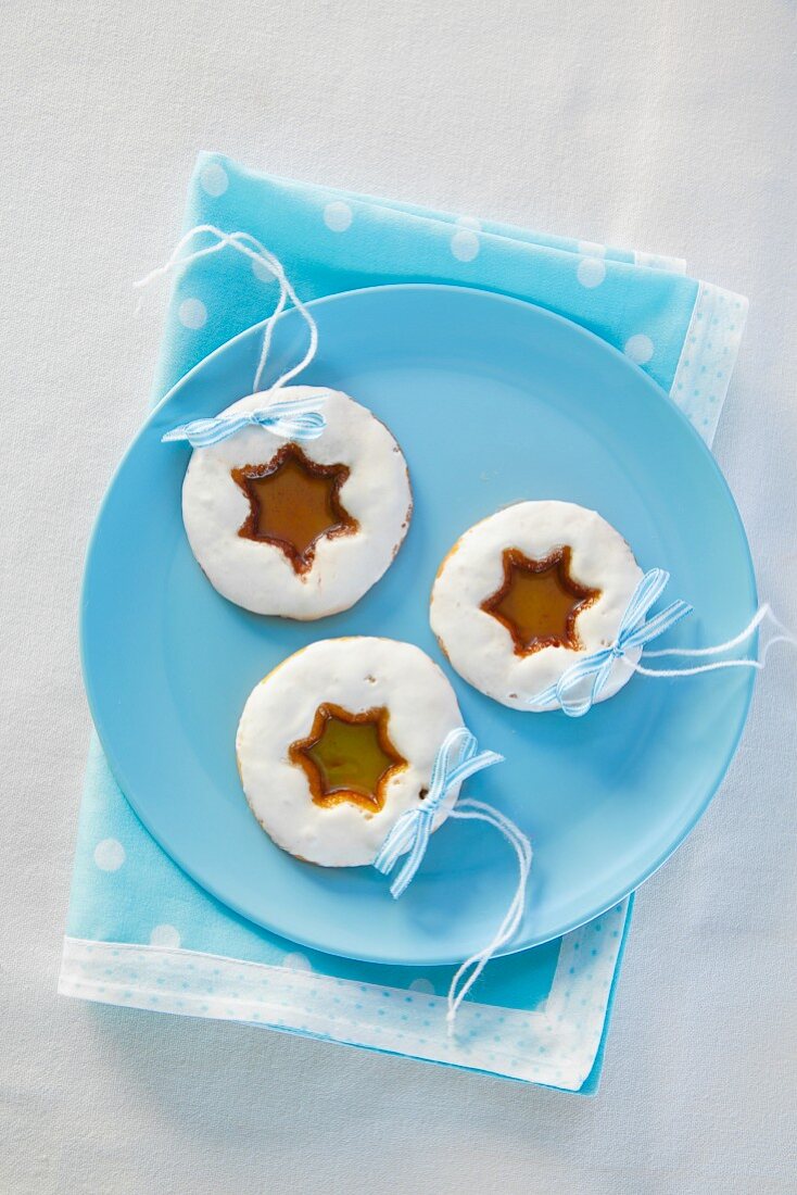 Three Christmas biscuits with star-shaped candy-filled holes
