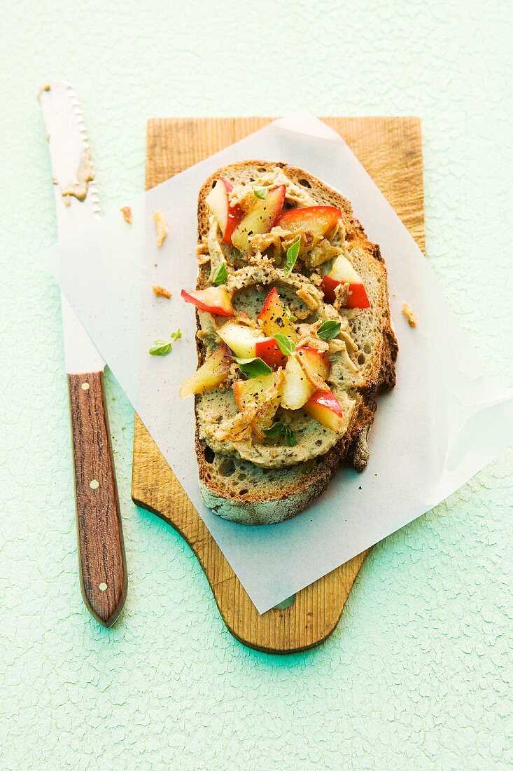 A slice of bread topped with liver sausage and apple