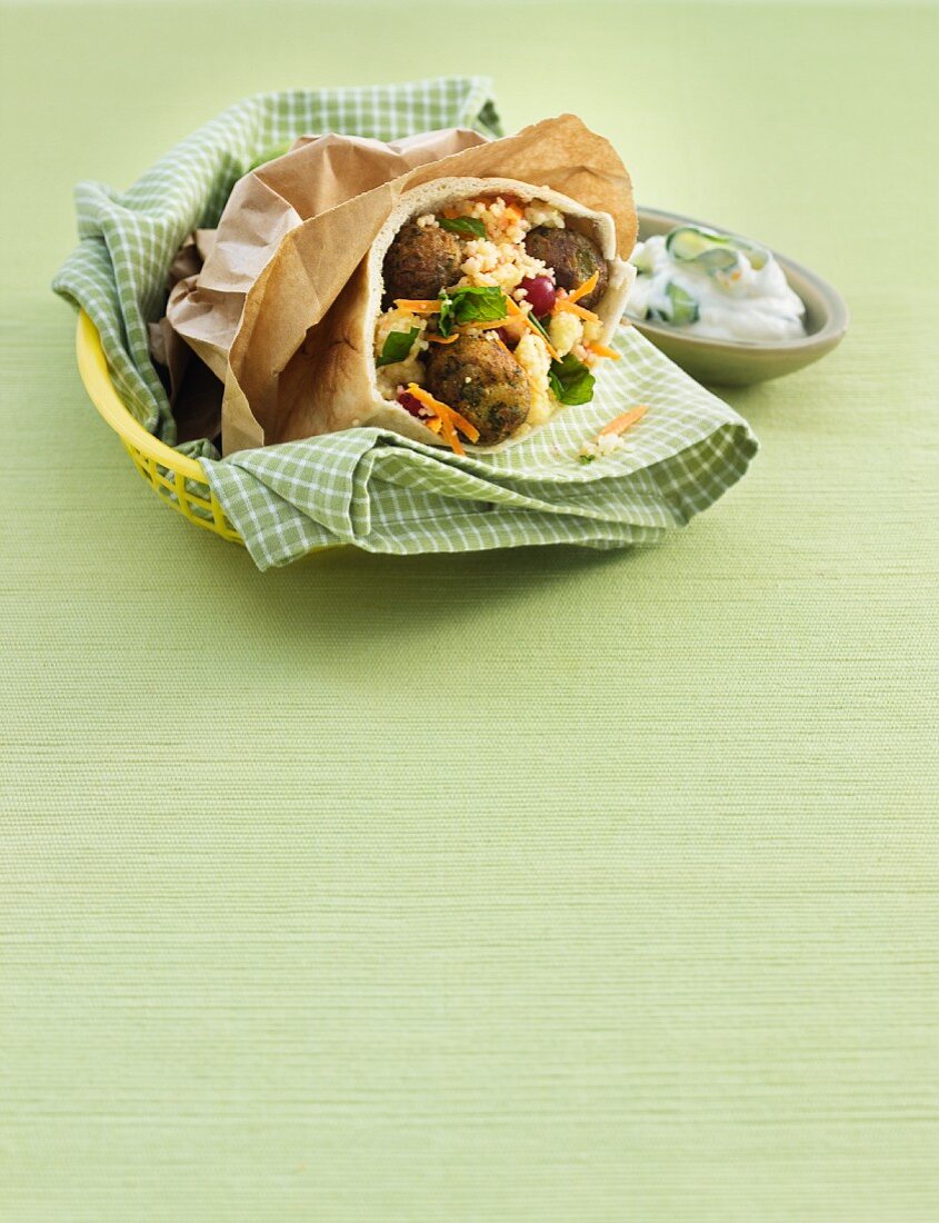 Pita bread with falafel and couscous, with a side of cucumber yogurt