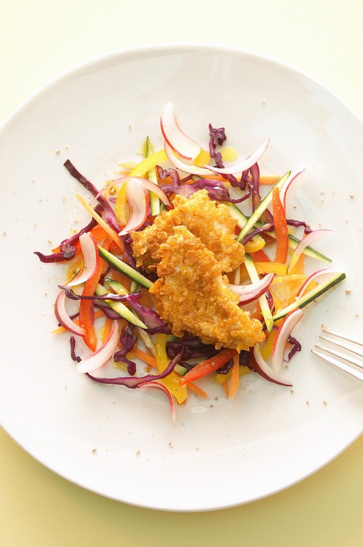 A raw salad with breaded chicken