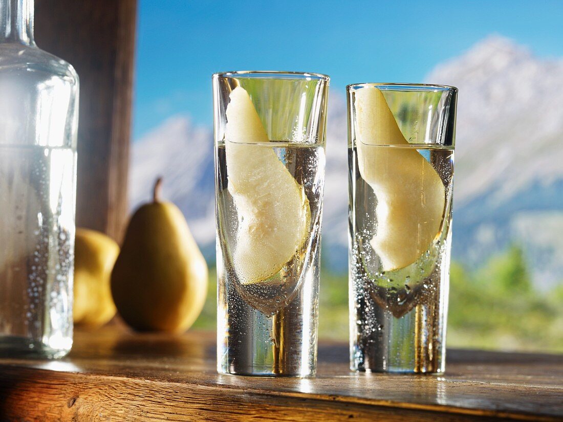 Two glasses of William's pear schnapps against an alpine backdrop