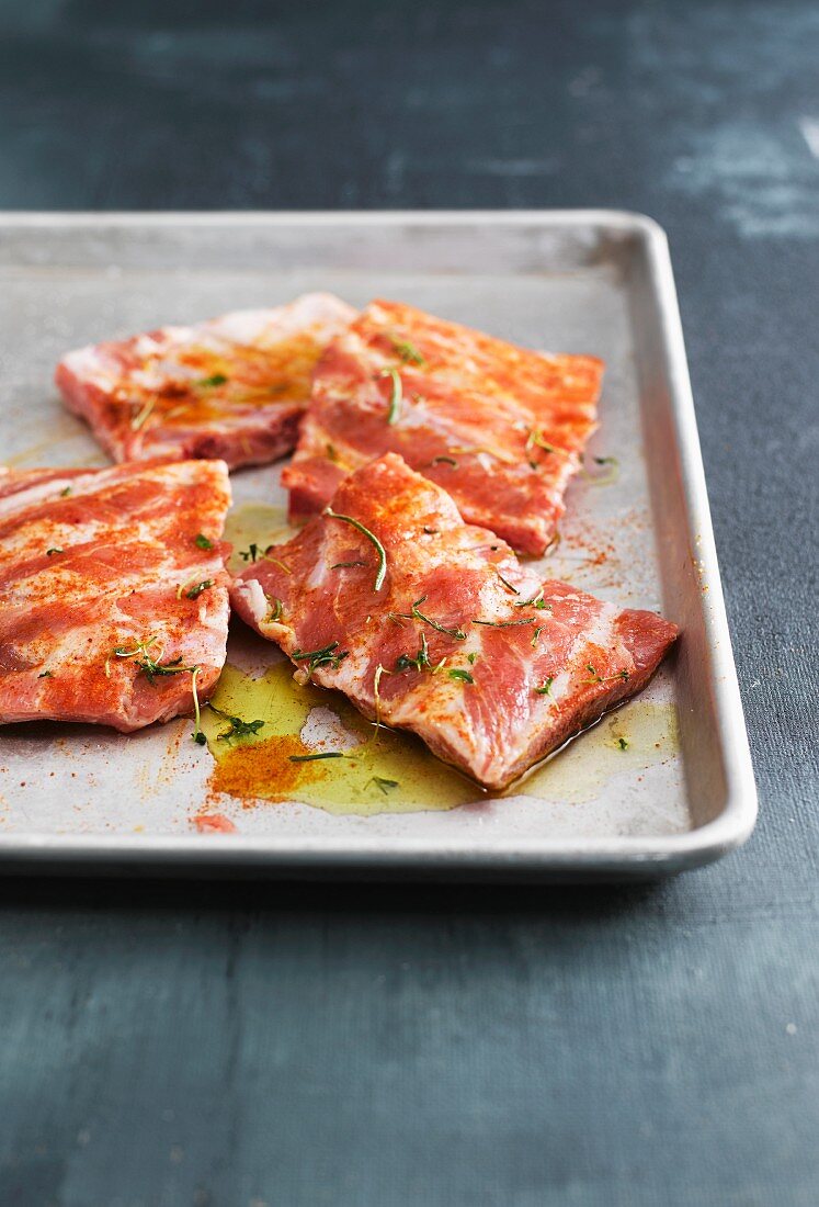 Marinated pork ribs on a baking tray