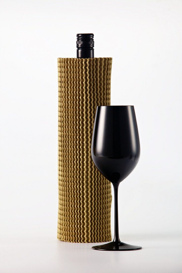 Blind wine tasting: concealed wine bottle and black wine glass