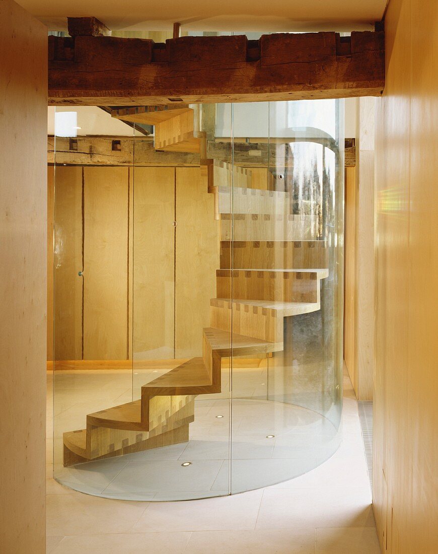 Wendeltreppe aus Holz mit gebogener Glaswand