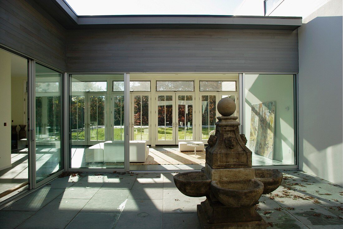 Old stone fountain in courtyard of modern villa