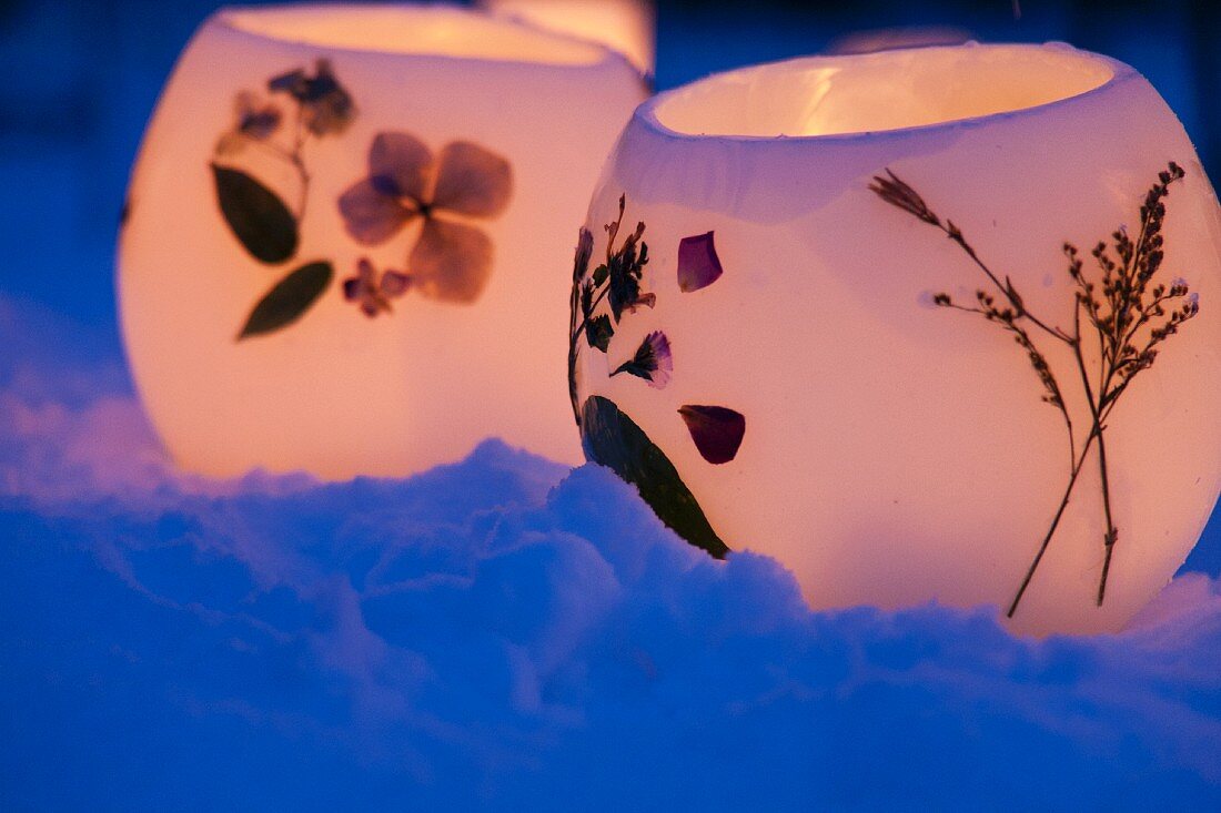 Tealight holders with pressed flowers in snow