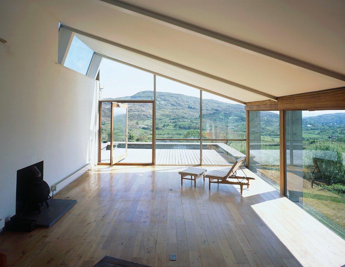 Armchair with footstool in empty living space with panoramic view