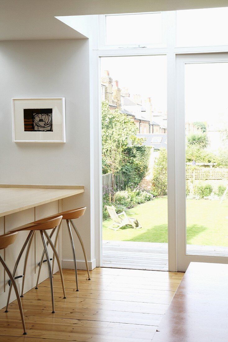 Kitchen counter with bar stools next to terrace door