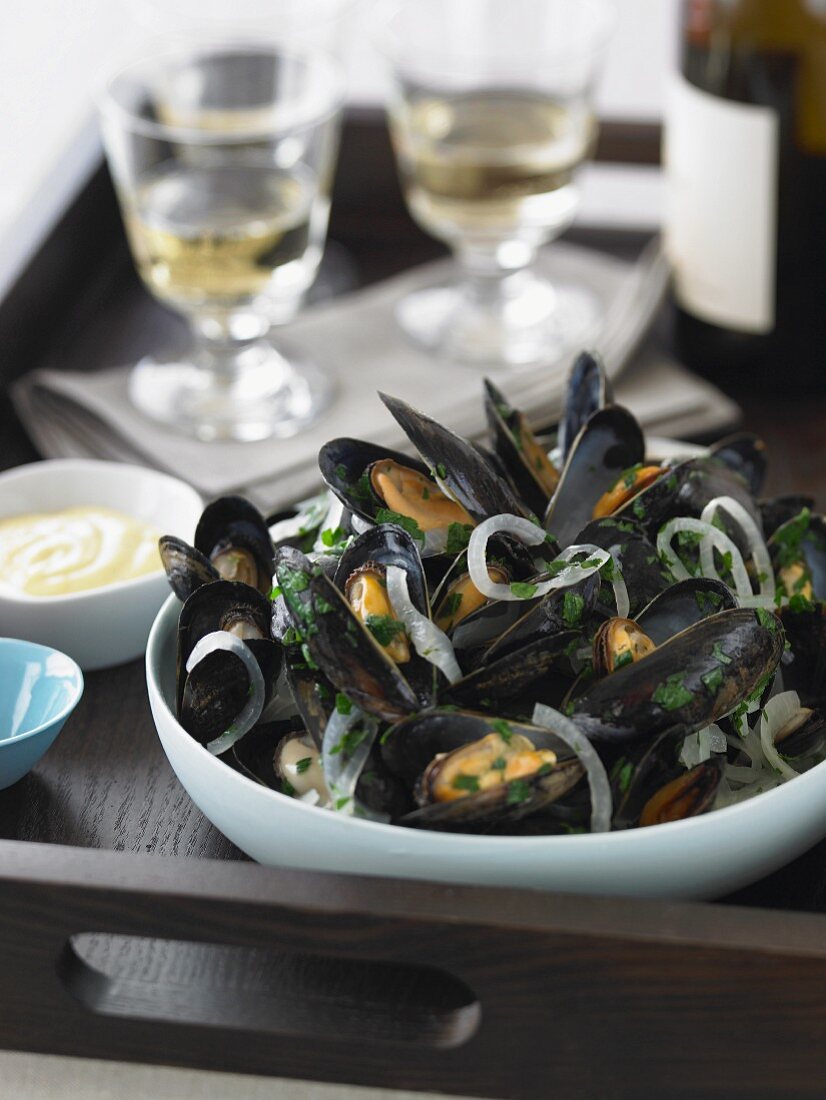 Bowl of Steamed Mussels with Glasses and Bottle of White Wine on a Tray