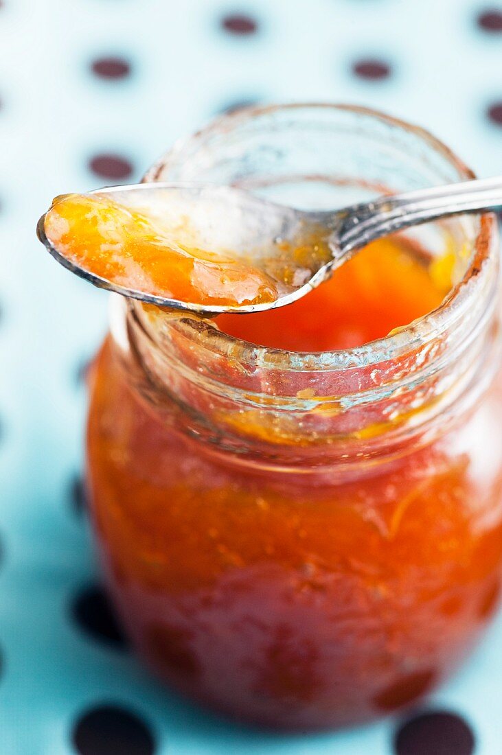 Aprikosenmarmelade in einem Glas und auf Löffel