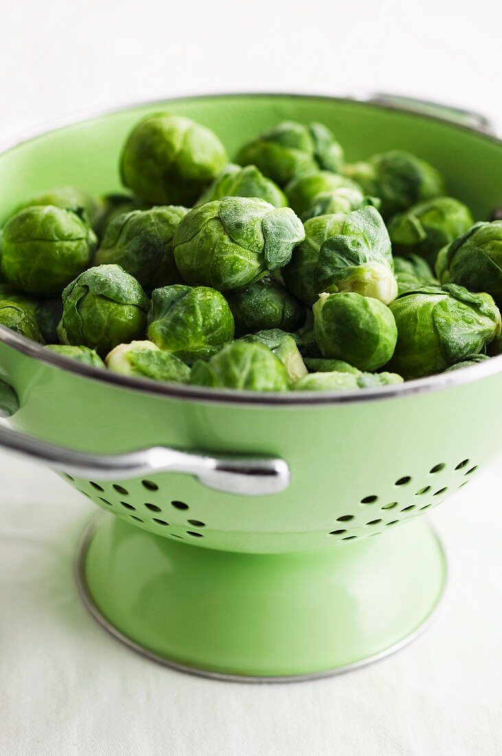 Fresh Brussels Sprouts in a Green Colander