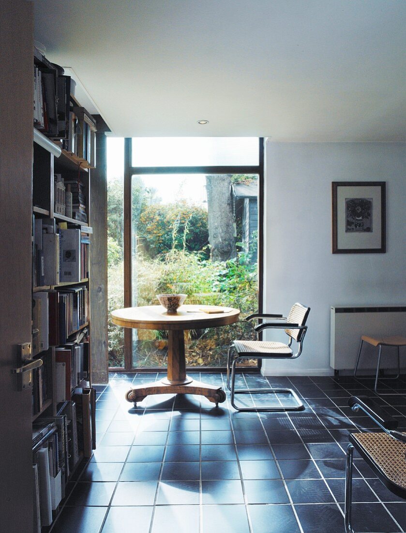 Runder Tisch und Stuhl in einem Arbeitszimmer mit Bücherregal