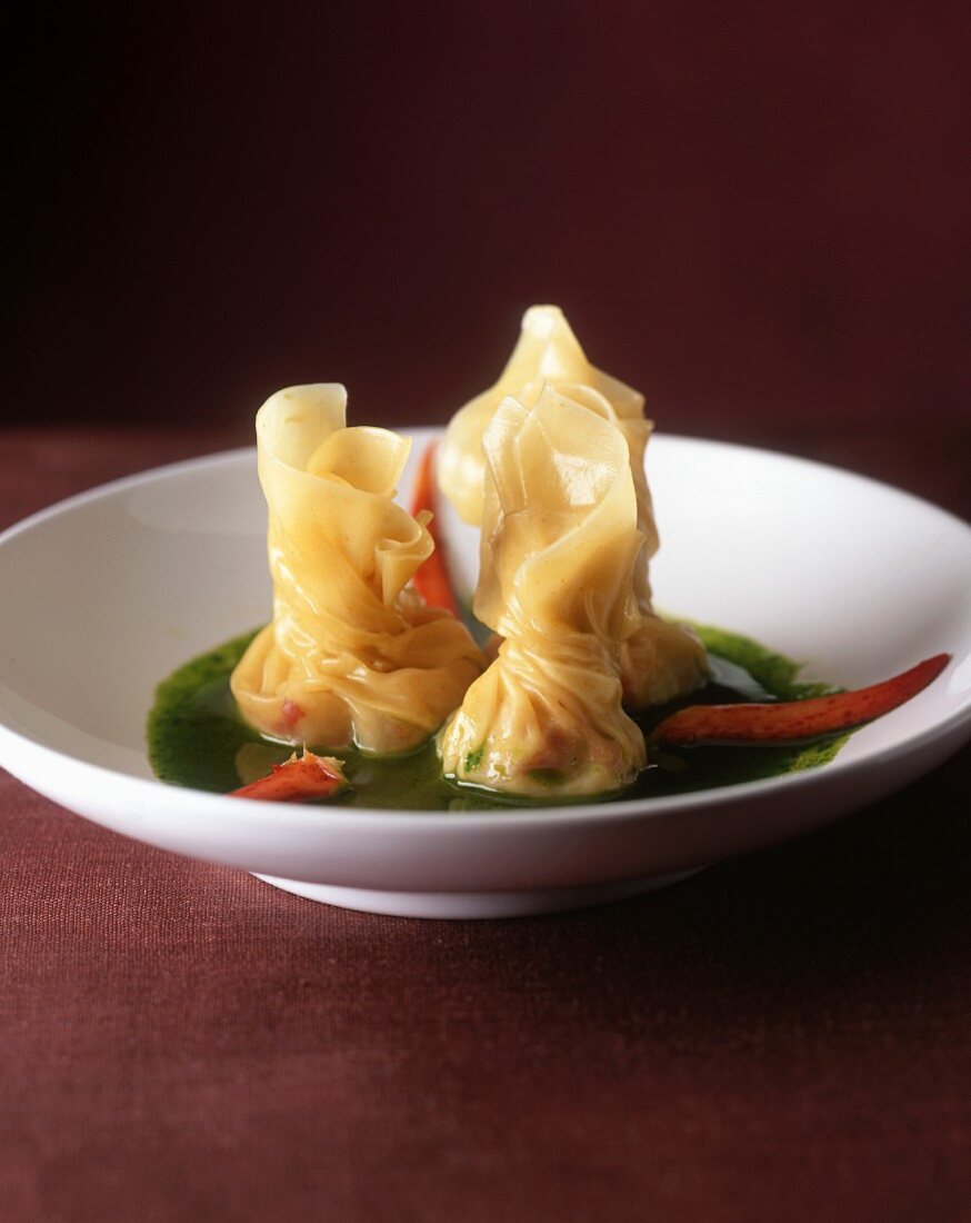 Pastry parcels with lobster on parsley sauce