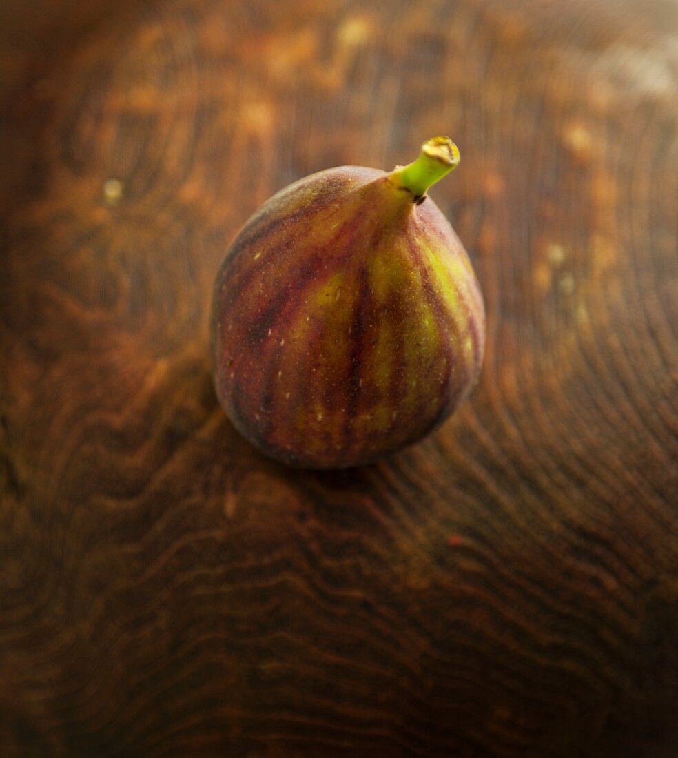One Fig on Wooden Background